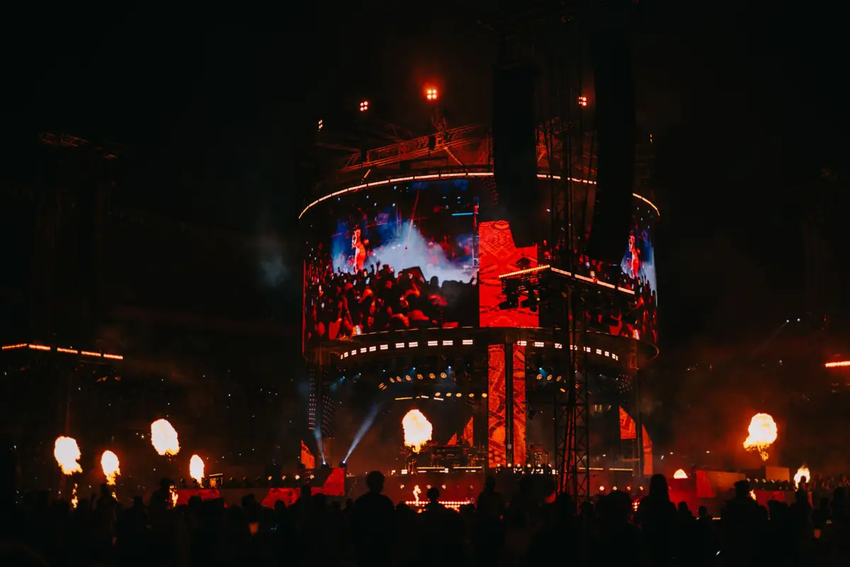 Crowd facing a live stage under warm lights